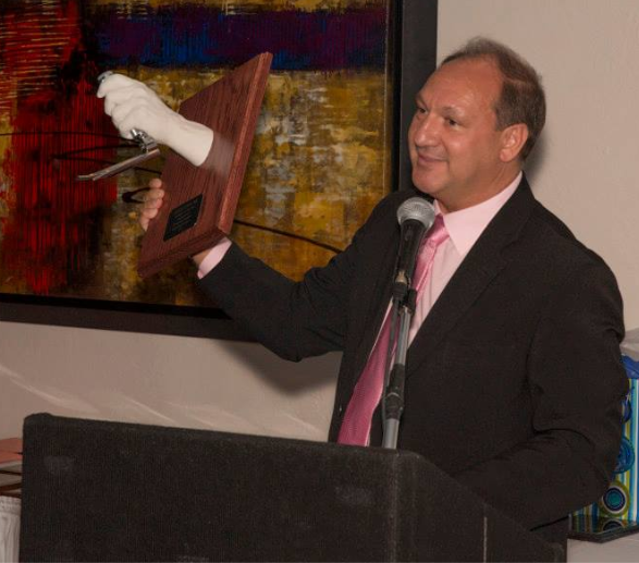 Dr. John C. Sakles holding a custom hand-cast award crafted by Grace Irene, founder of Keepsakes of Triumph, showcasing excellence in airway management