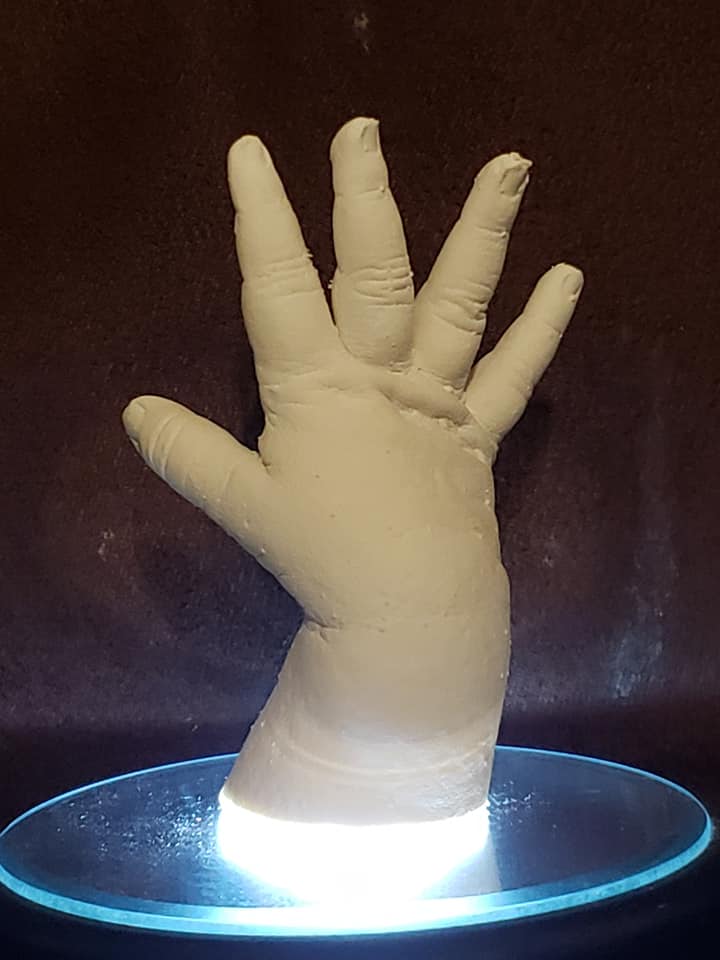  Baby hand sculpture illuminated on a display base, symbolizing preserving milestones and capturing newborn handprints.