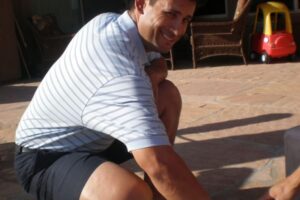 Person crouches during a handcasting session setup outdoors, preparing for the mold