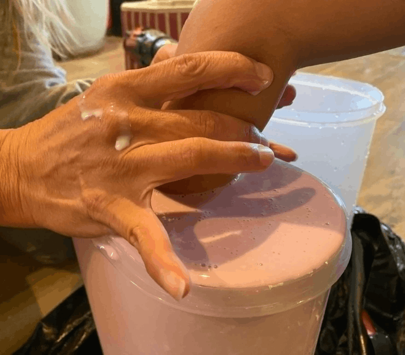 Child's hand being cast in pink alginate molding material at Keepsakes of Triumph studio in Tucson