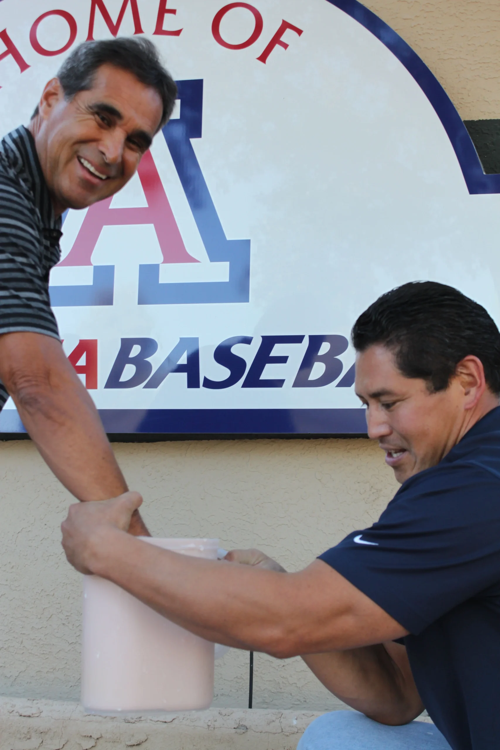 Coach Andy Lopez, two-time NCAA College World Series champion, getting his hand cast at the University of Arizona "Home of Arizona Baseball" sign with Keepsakes of Triumph